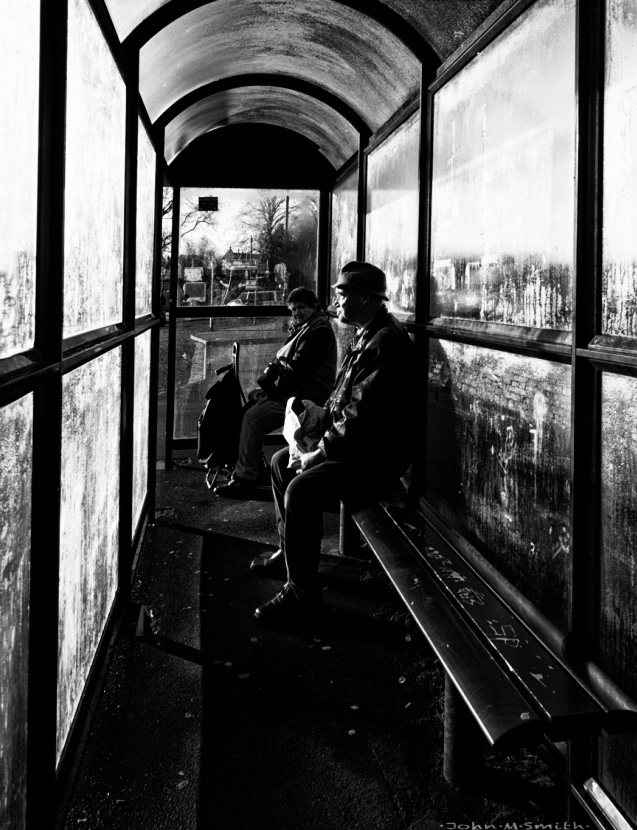 Man alone in bus shelter